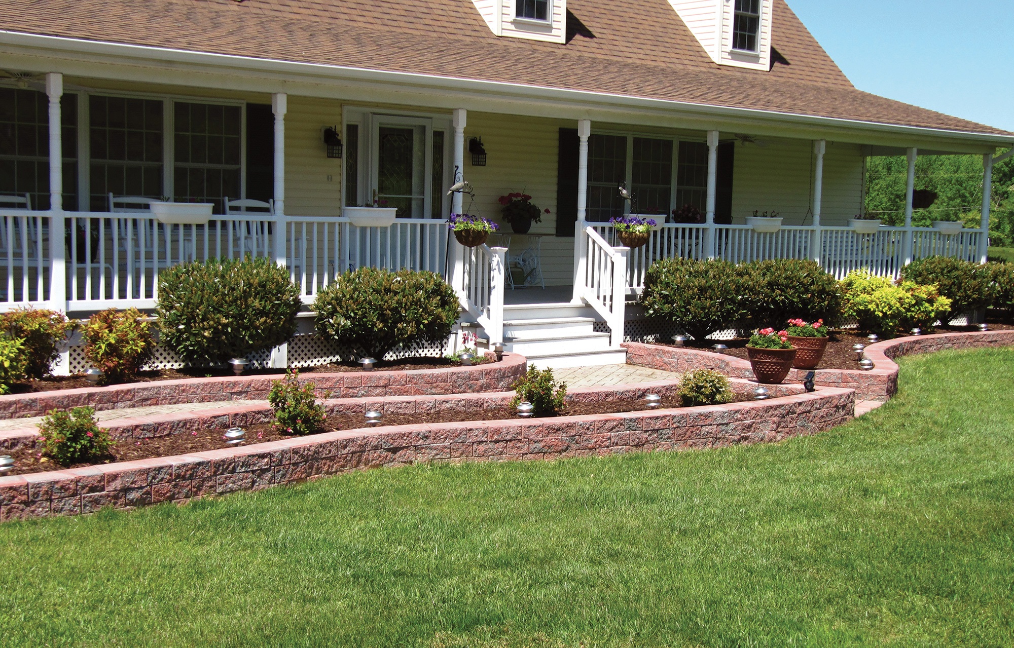 A close-up of stacked red garden wall bricks with a textured surface and natural weathering, used for outdoor landscaping.