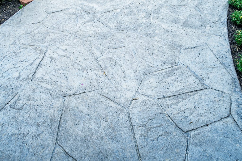 First rain drops hitting a stamped concrete walkway