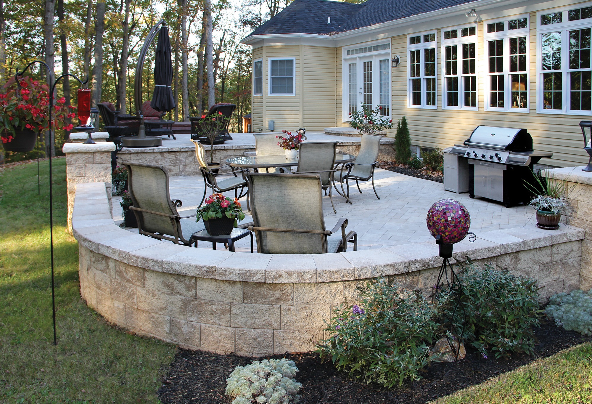 Smooth gray capping stones arranged atop a brick garden wall, providing a finished edge and protection.